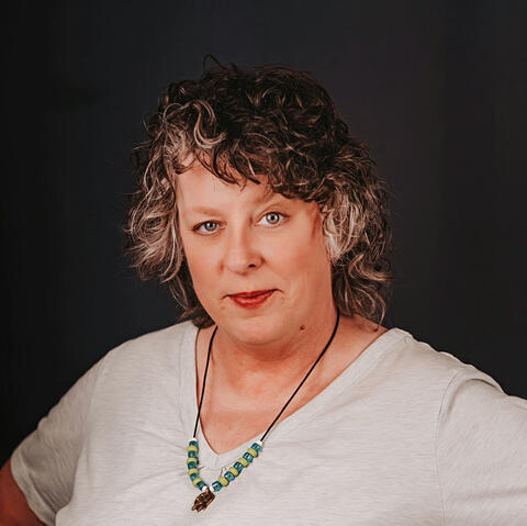 image of a woman with curly hair and a smirk